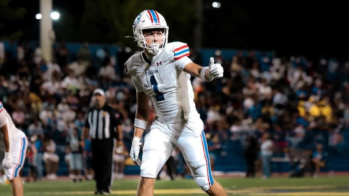 Folsom wide receiver Rob Larson signals on the field during a night game